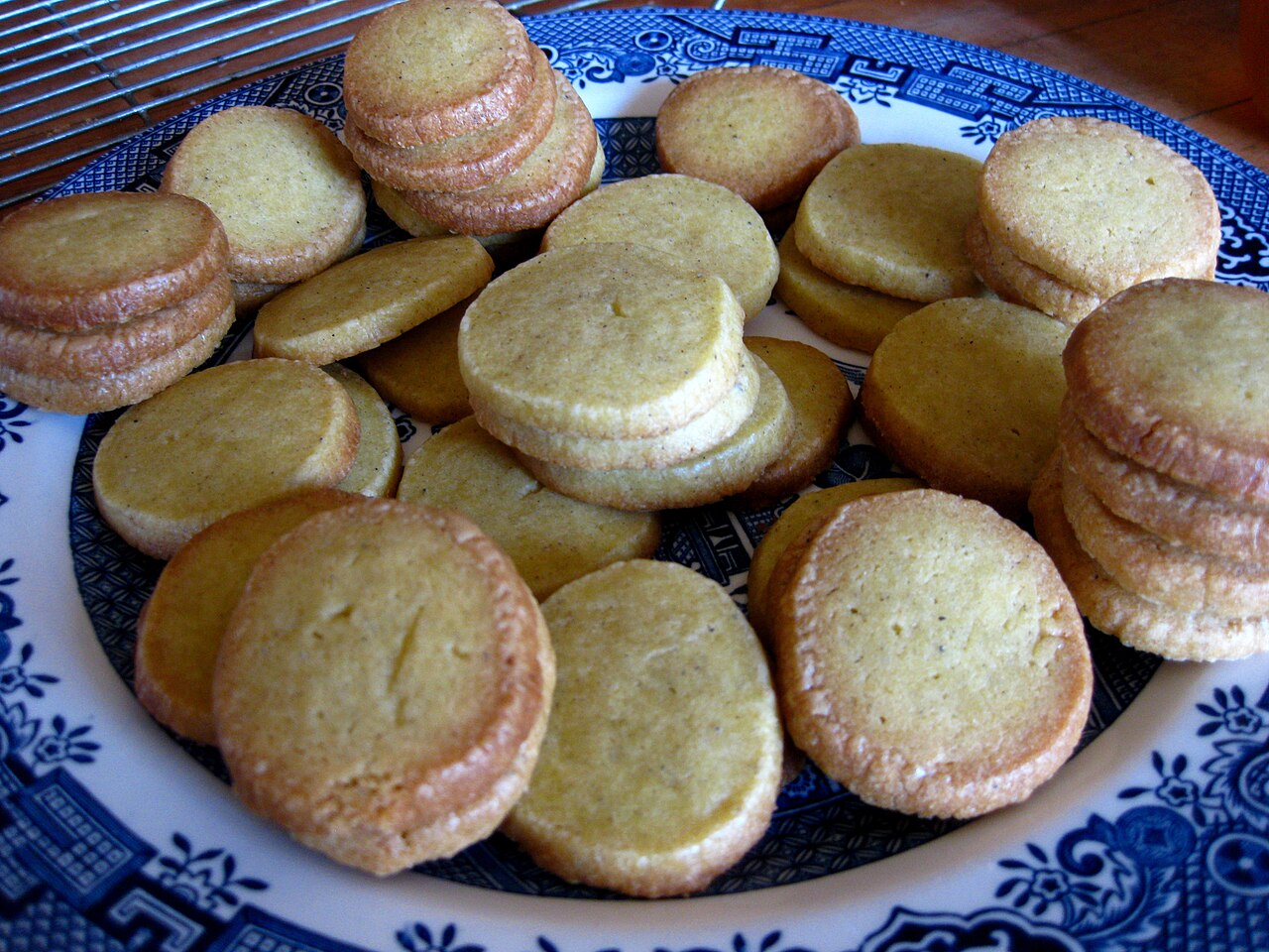 A plate filled with round cardamom shortbread biscuits