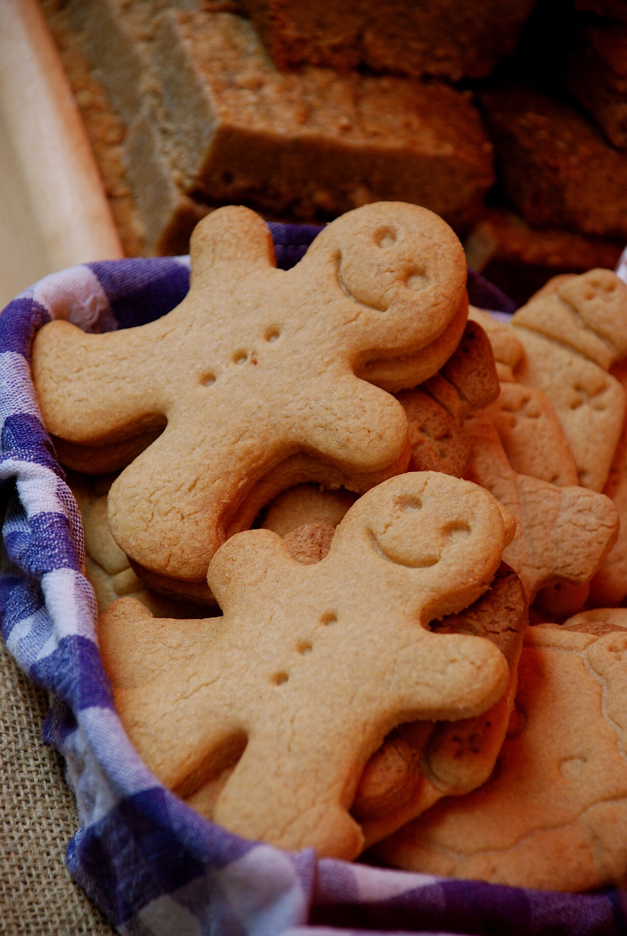 Freshly baked gingerbread people arranged in a lined basket